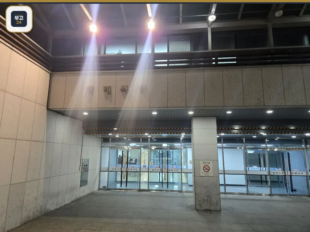 파주의료원장례식장 외부 출입구와 간판, 조명이 보임