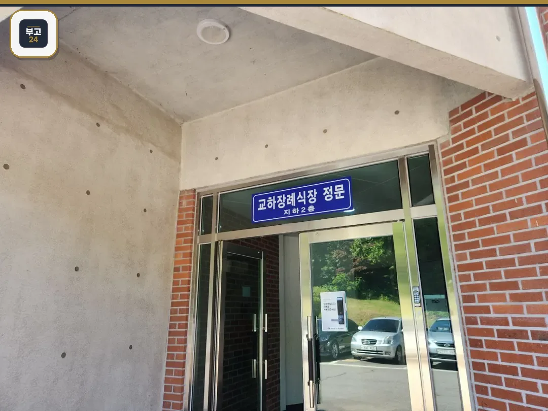 붉은 벽돌 외벽과 유리문이 있는 교하장례식장 정문 입구 모습